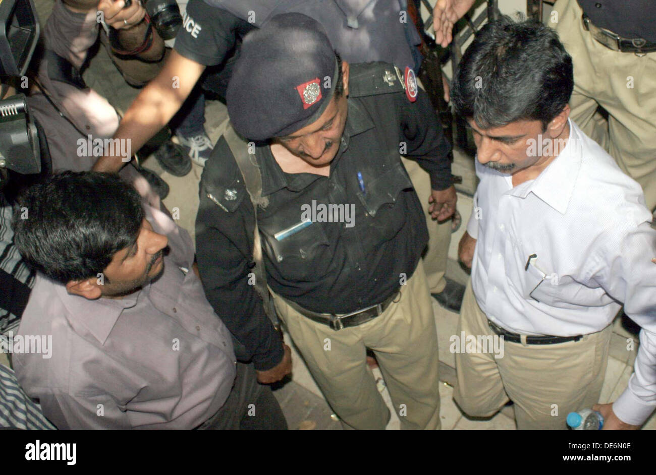 Police officials escort Muttahida Qaumi Movement (MQM) sector in-charge and former MPA Nadeem Hashmi after case hearing at Anti Terrorism Court in Karachi on Thursday, September 12, 2013. Muttahida Qaumi Movement (MQM) sector in- charge and former MPA Nadeem Hashmi was sent on a 7-day physical remand by the Anti- Terrorism Court (ATC), Hashmi was arrested for allegedly firing at a police mobile and killing two police personnel Muhammad Ali and Arif in Hyderi. Hyderi police arrested Hashmi on charges of terrorism and murder in a raid on his house in North N... Stock Photo