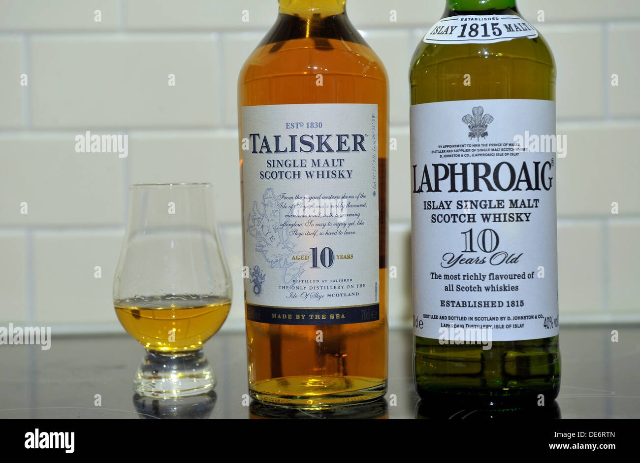 Bottles of Scottish single malt whiskies. From left, Talisker and Laphroaig, and whisky glass. Stock Photo