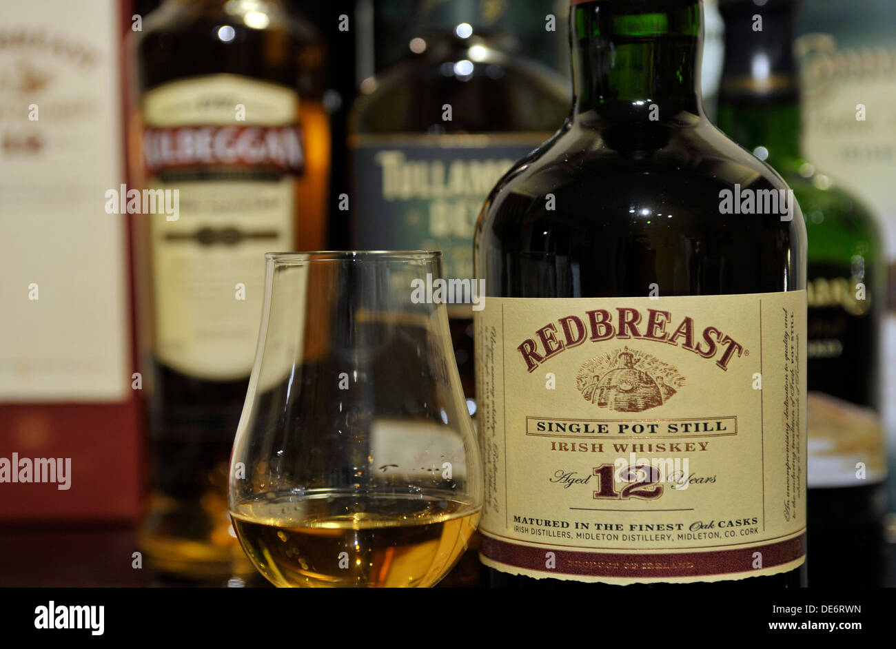 Bottle of aged 12 years Redbrest single pot still Irish whiskey and whiskey glass. Stock Photo