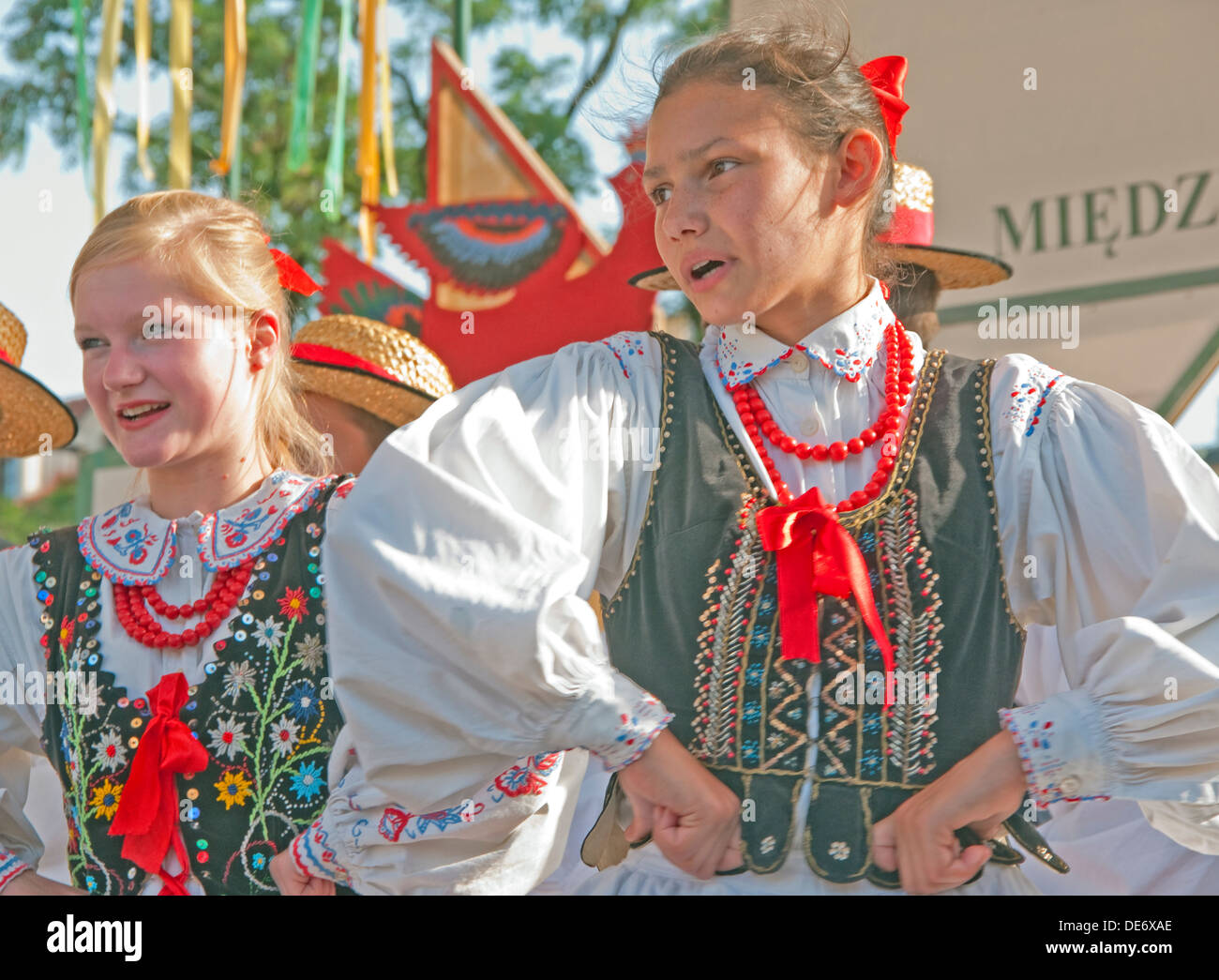 Folk dancers in Krakow's Main Market Square wearing traditional embroidered clothing. Stock Photo