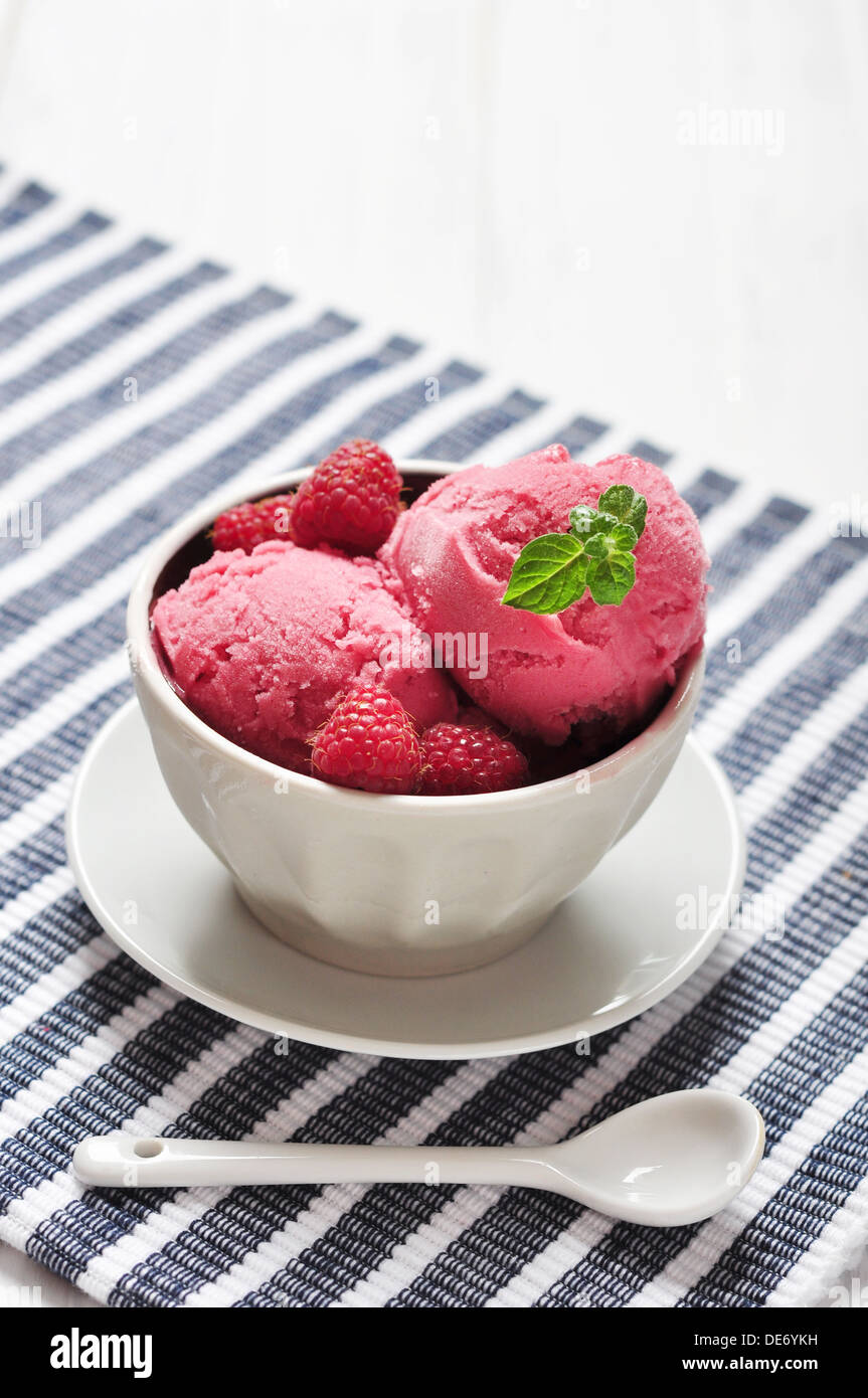 Raspberry ice cream in ceramic bowl with fresh berries and mint Stock Photo