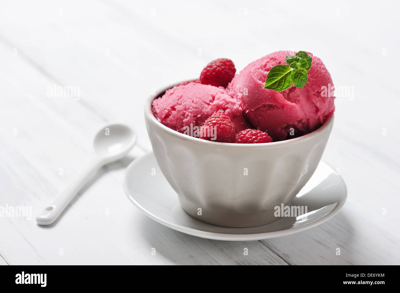 Raspberry ice cream in ceramic bowl with fresh berries and mint Stock Photo