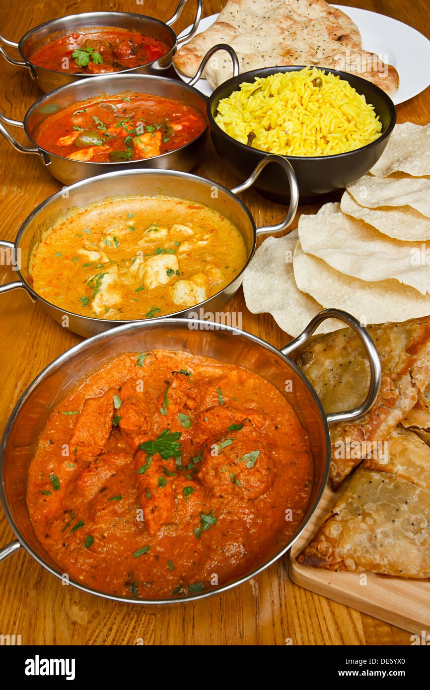 Selection of indian curries with pilau rice, naan bread, poppadoms and samosas a popular buffet choice Stock Photo