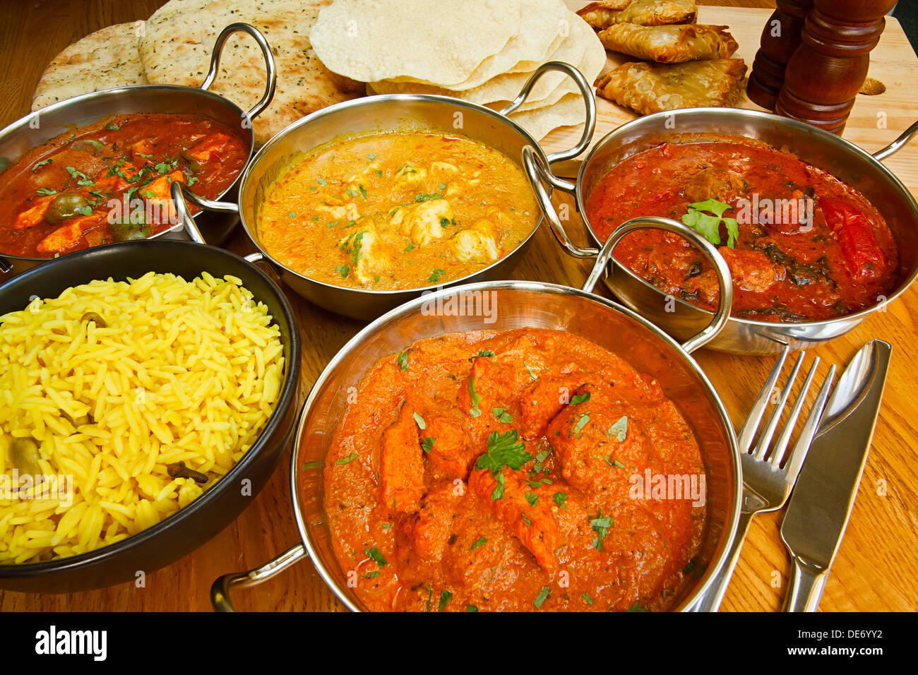 Varied selection of indian cuisine on table including Chicken Tikka, beef rogan josh, chicken jalfrezi and chicken korma. Stock Photo