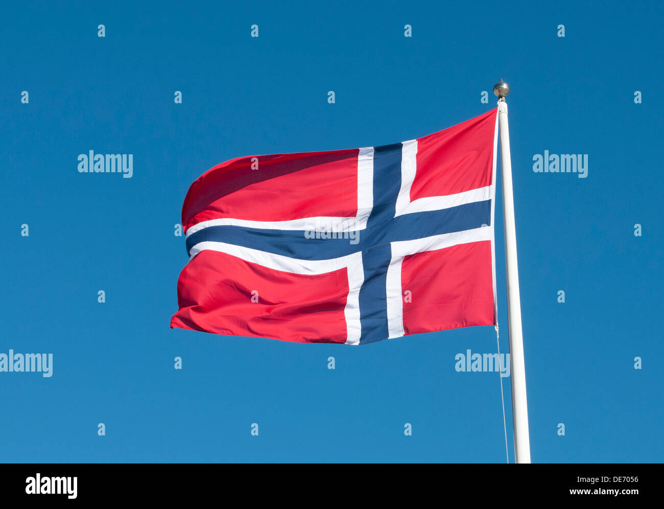 Norwegian flag flying against blue sky Stock Photo