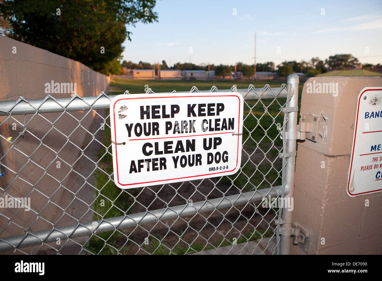 Sign at dog park asking owners to clean up after their dog. Stock Photo