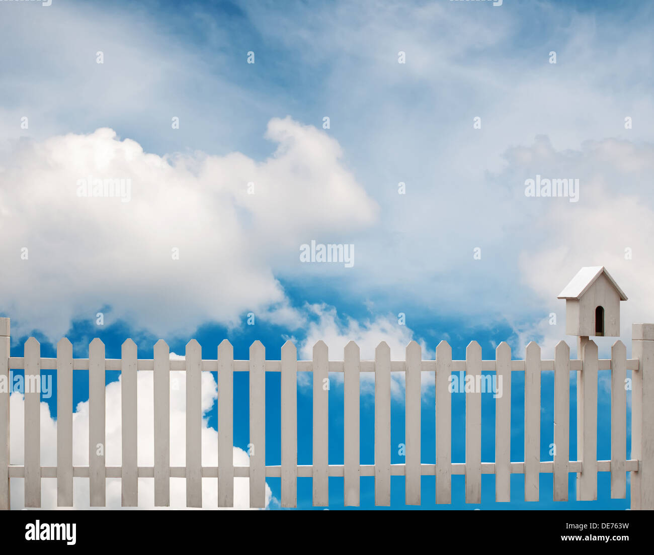 white fence with bird house and blue sky Stock Photo - Alamy