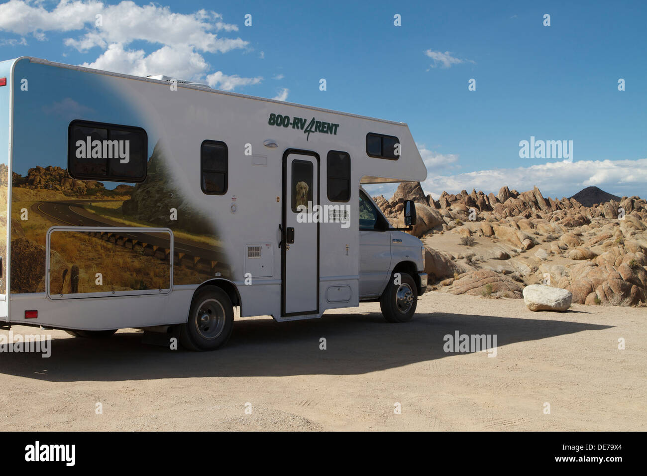 A Cruise America RV parked in the Alabama Hills west of Lone Pine California with a similar paint job as the background Stock Photo