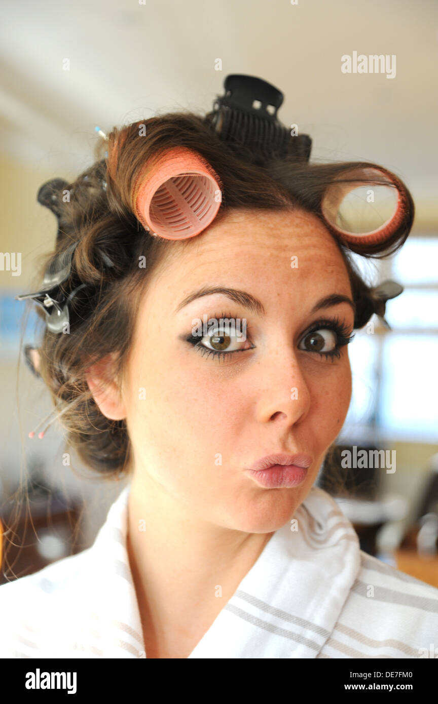 Young beautiful woman 20s with rollers in her hair and wearing eyelash extensions getting ready