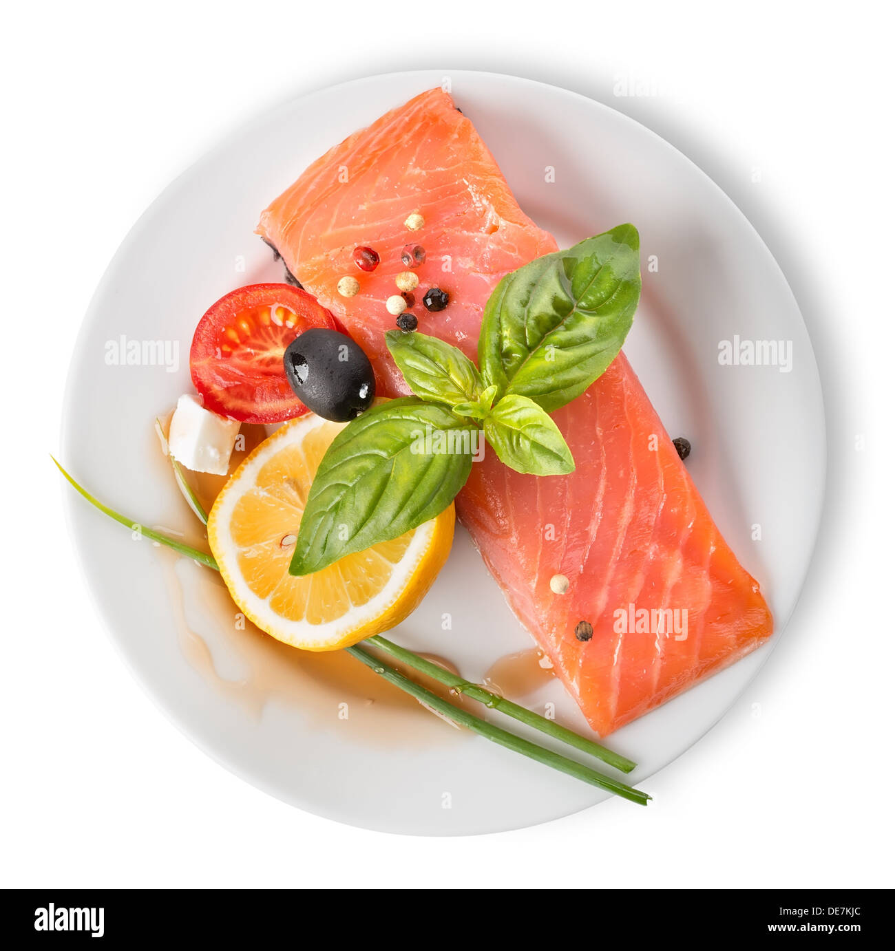 Red fish fillet with vegetables in plate isolated on white Stock Photo