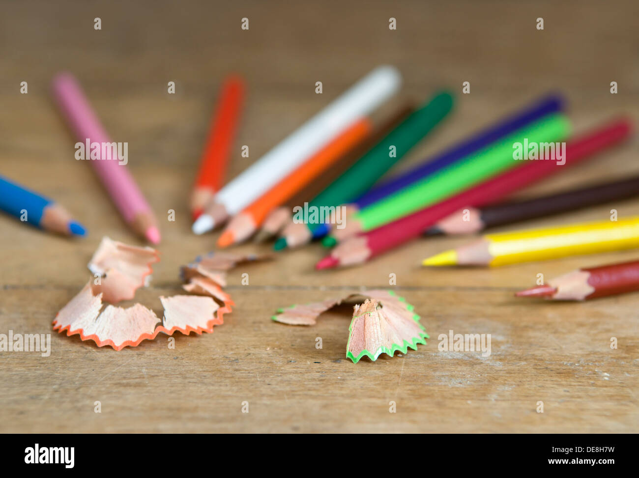 Top view of colored pencils with shavings and pencil sharpener over white  background. top view Stock Photo - Alamy