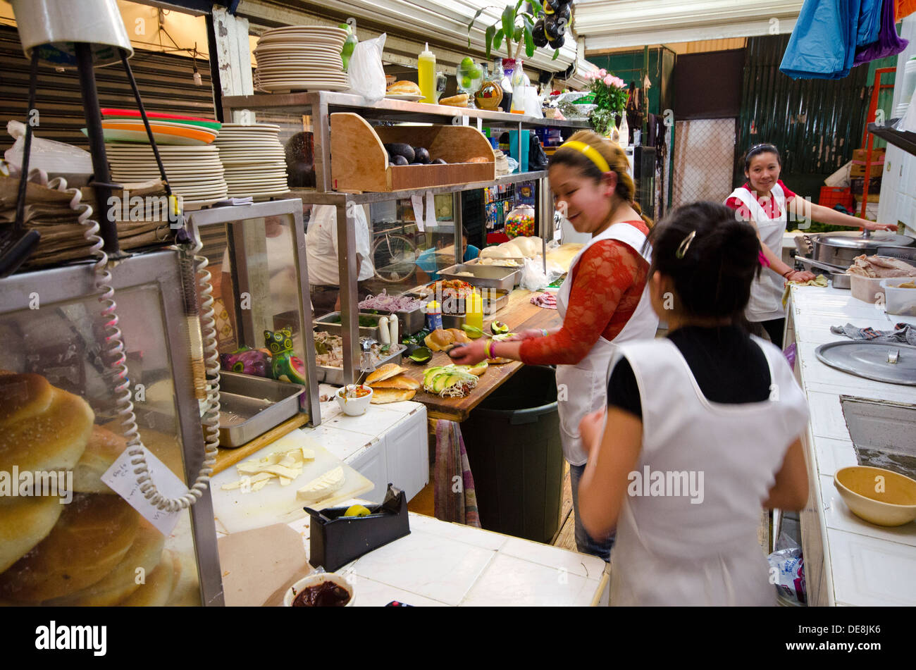 Women preparing food in the kitchen of a snack bar in the indoor market at Cholula in the state of Puebla in Mexico Stock Photo