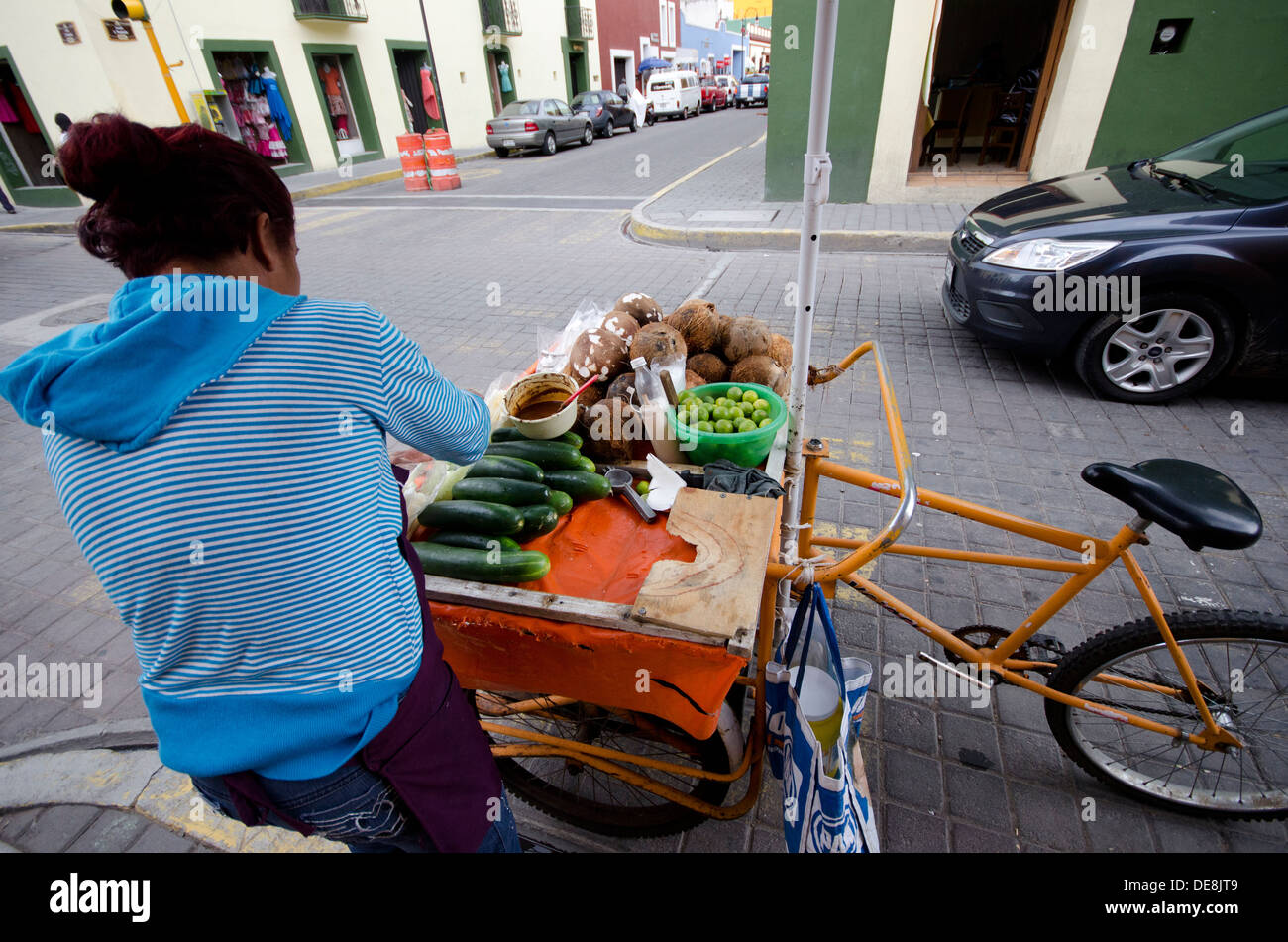 Mobile street vendor selling sliced cucumber and coconut with lime juice and chili as a healthy snack, in Cholula, Mexico Stock Photo