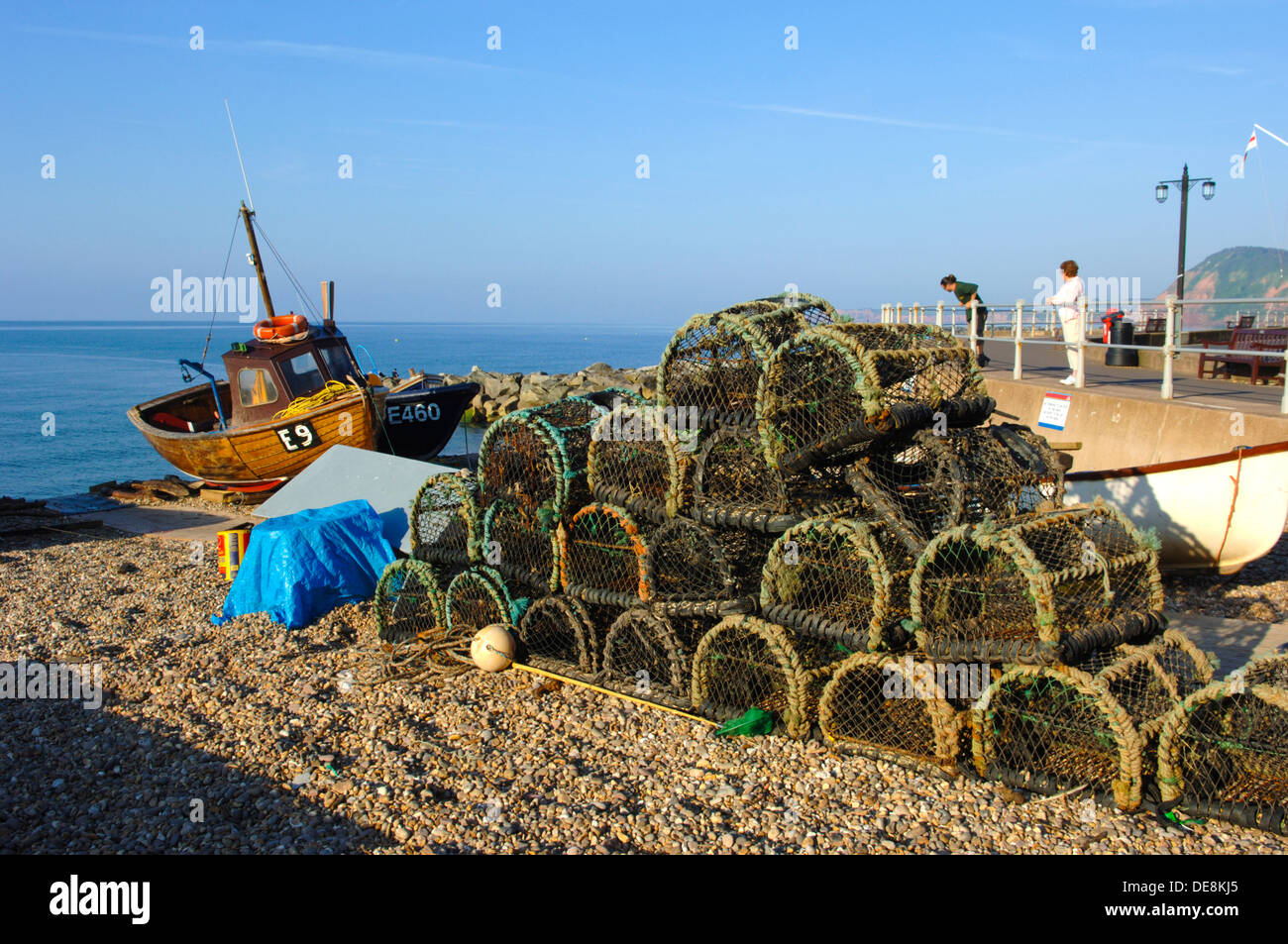 A fishing boat and baskets on the beach at Sidmouth, Devon, England, UK
