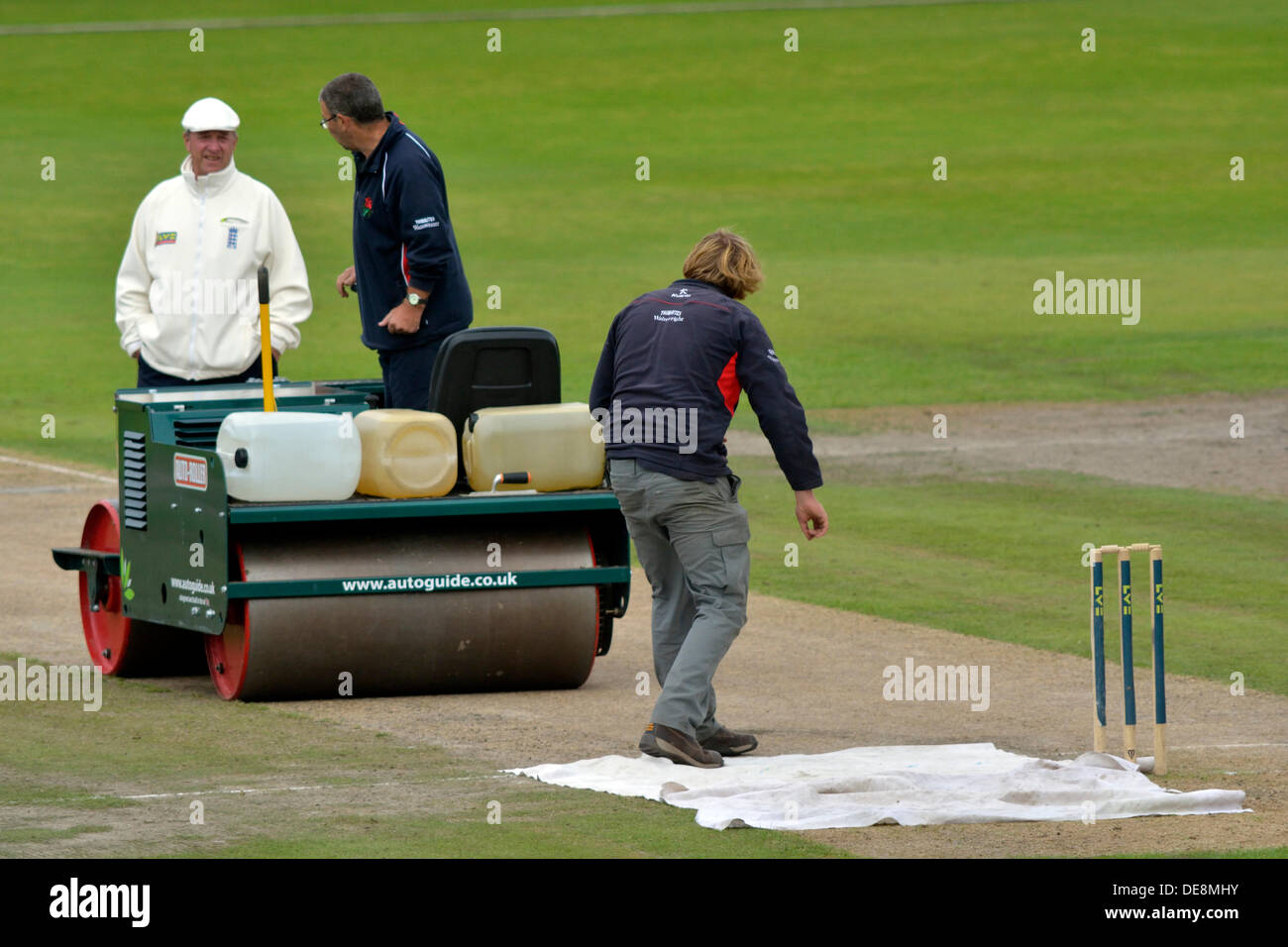 The Lancashire groundstaff prepare the wicket before the start of Leicestershire's innings on day 3 of the four-day County Championship match. Lancashire v Leicestershire, Emirates Old Trafford, Manchester, UK  13 September 2013 Credit:  John Fryer/Alamy Live News Stock Photo