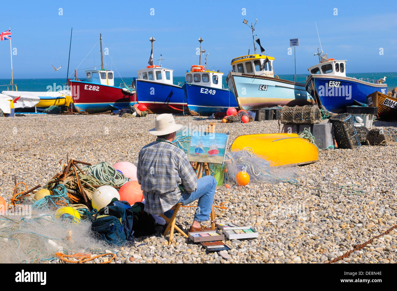 Artist painting on the beach at Beer Devon England Stock Photo
