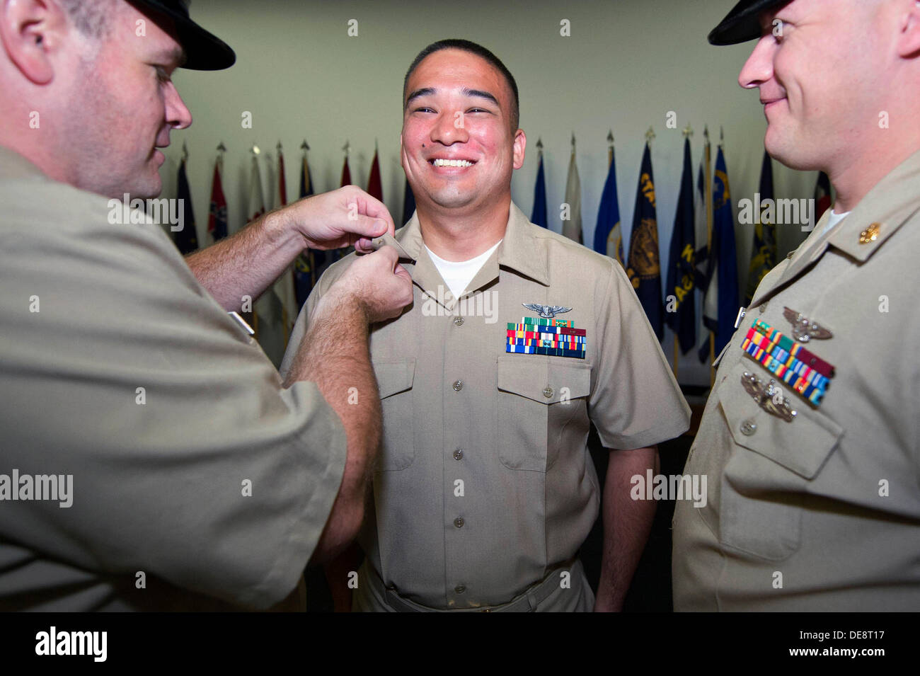 US Navy sailor Don Watanabe smiles as he has his anchors pinned on during a chief pinning ceremony held at the Naval Air Facility September 13, 2013 in Atsugi, Japan. Stock Photo