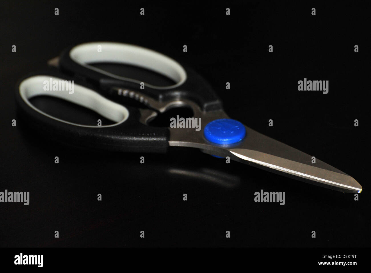 A par of household scissors against a black background Stock Photo - Alamy
