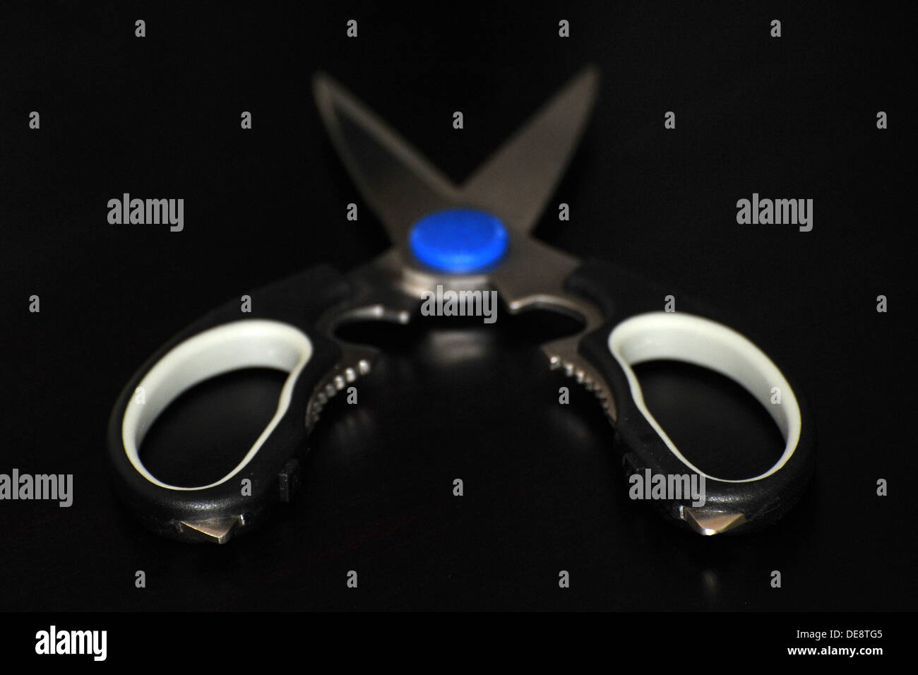 A par of household scissors against a black background Stock Photo - Alamy