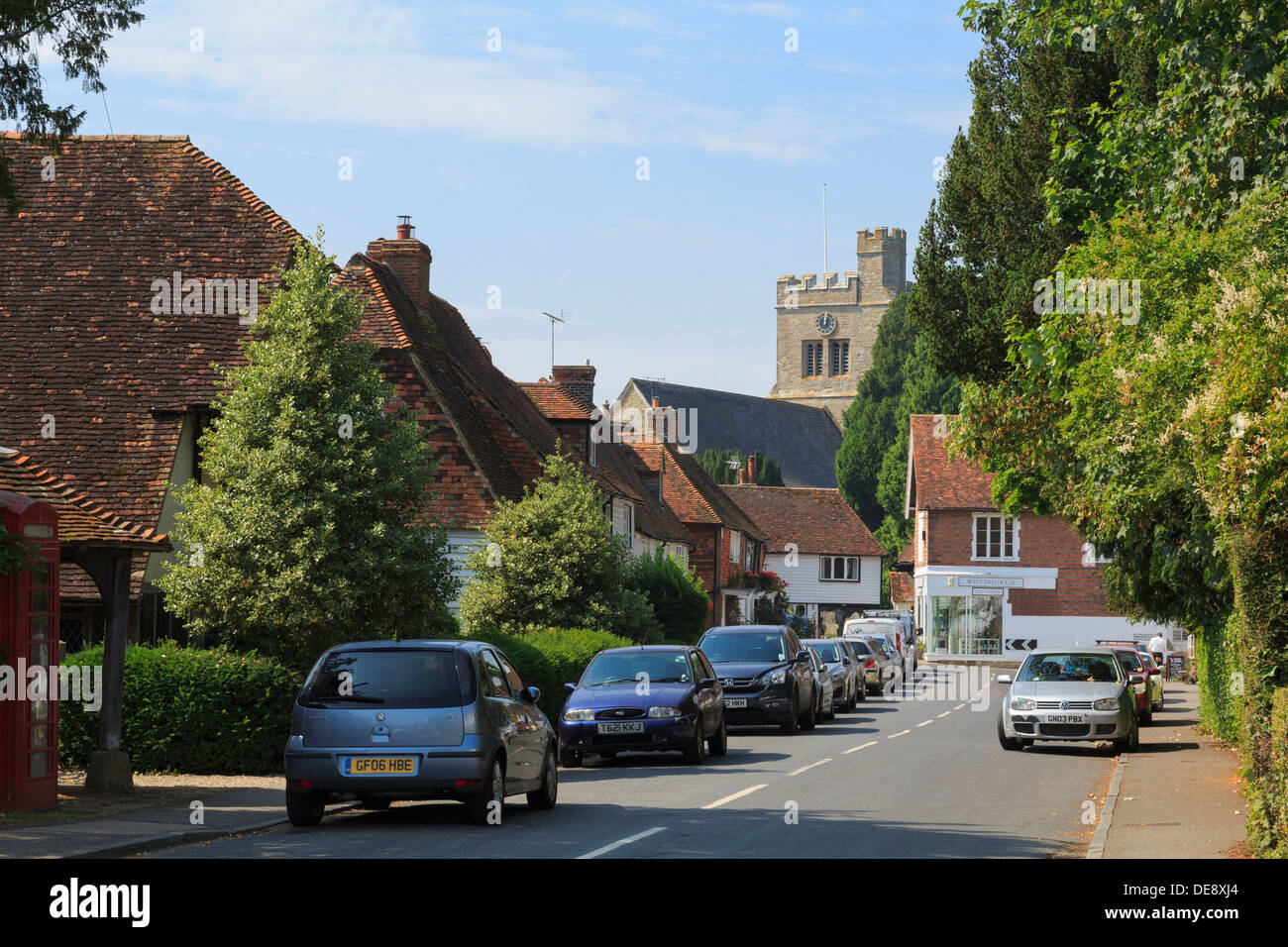 View to village church with cars parked along The Street, Smarden, Kent, England, UK, Britain Stock Photo