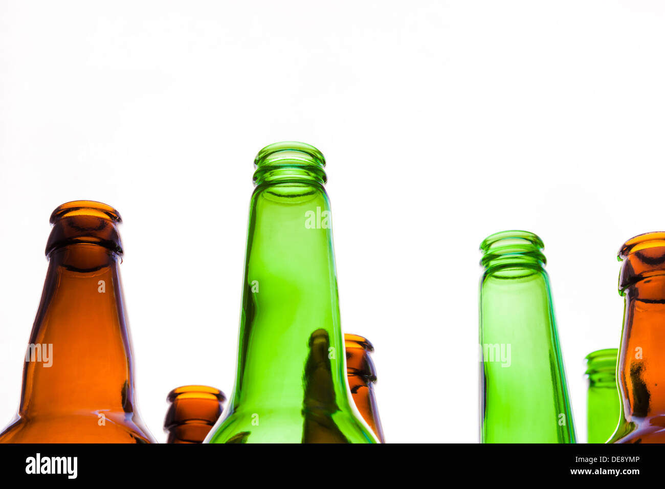 Looking up at the necks of empty beer bottles isolated on a white background. Stock Photo