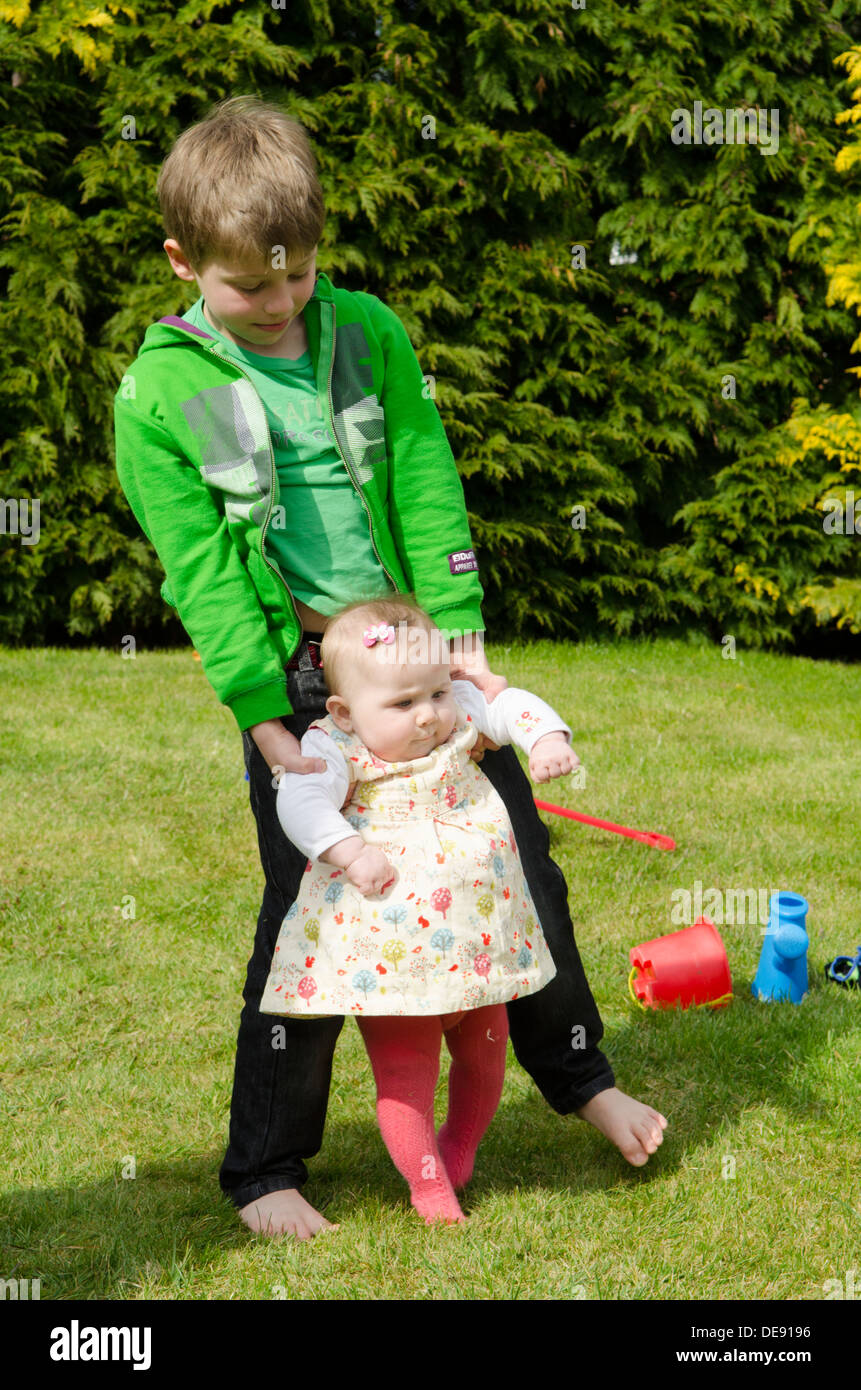 siblings eight year old boy with eight month old sister playing in