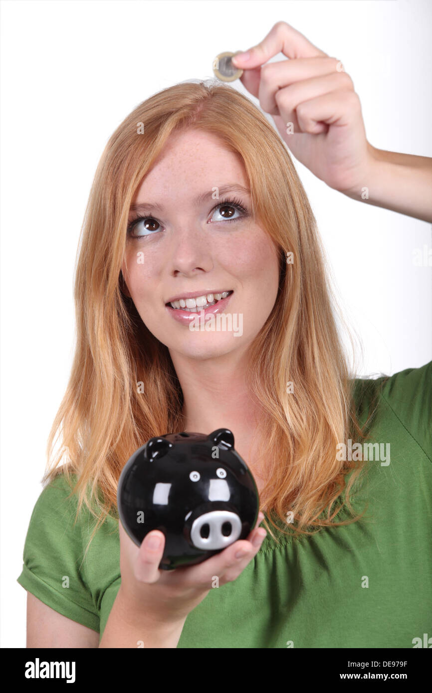 Young woman with a piggy bank Stock Photo - Alamy