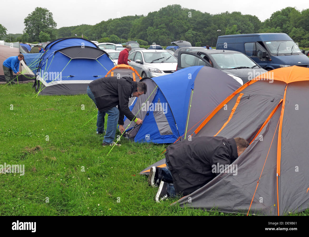 Happy campers erecting a tent at a festival or sporting event (F1 Grand Prix) Stock Photo