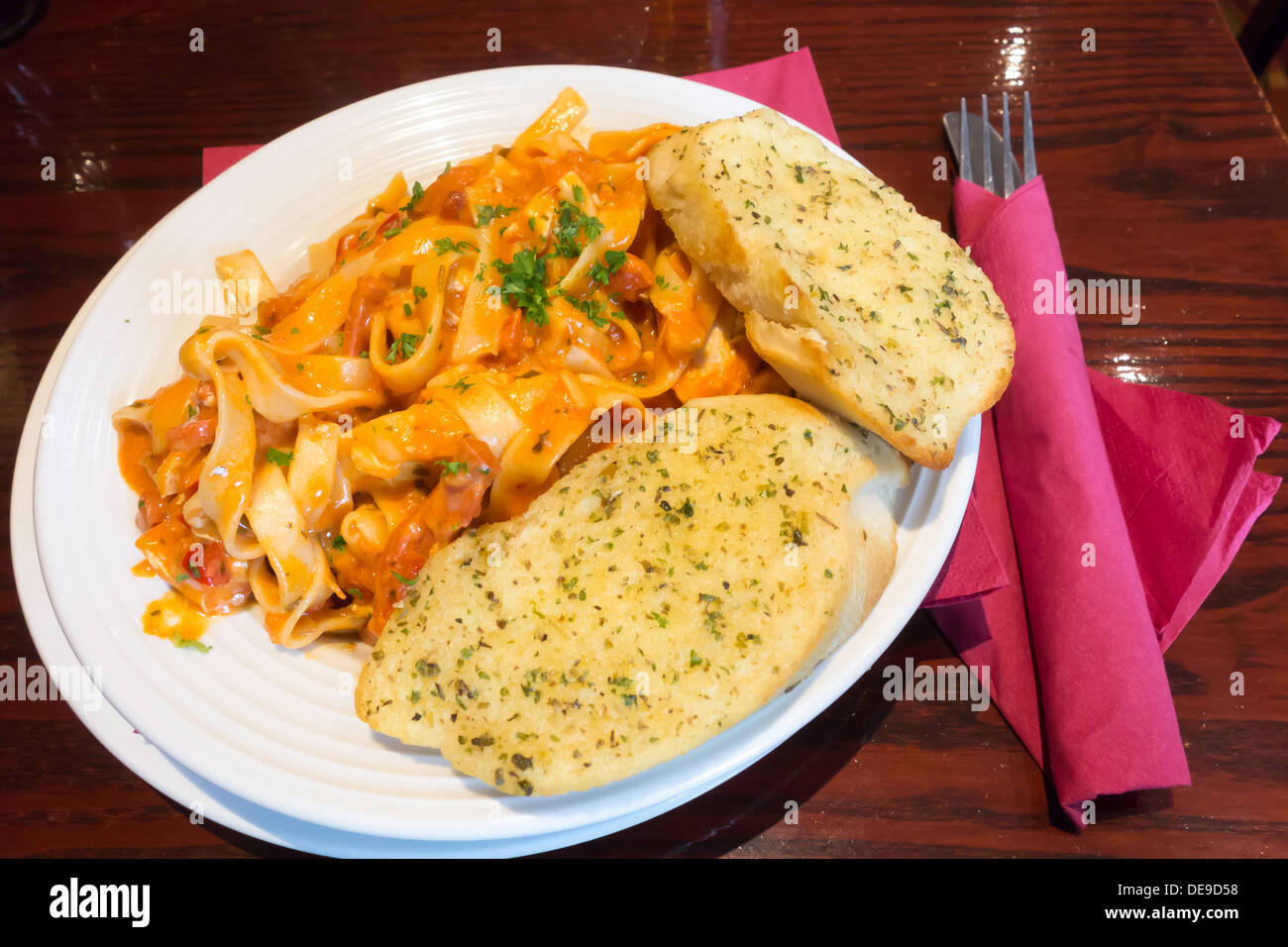 Pub food tasty evening meal of Chorizo and Chicken Tagliatelli with Arabiatta sauce and garlic bread Stock Photo