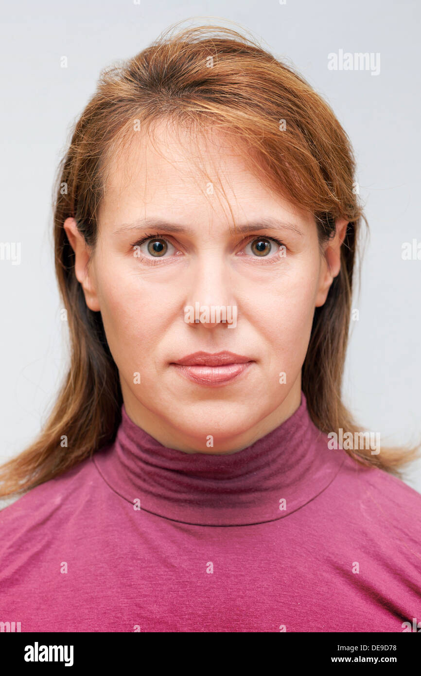 Closeup studio face portrait of young Caucasian ordinary woman isolated on gray background Stock Photo