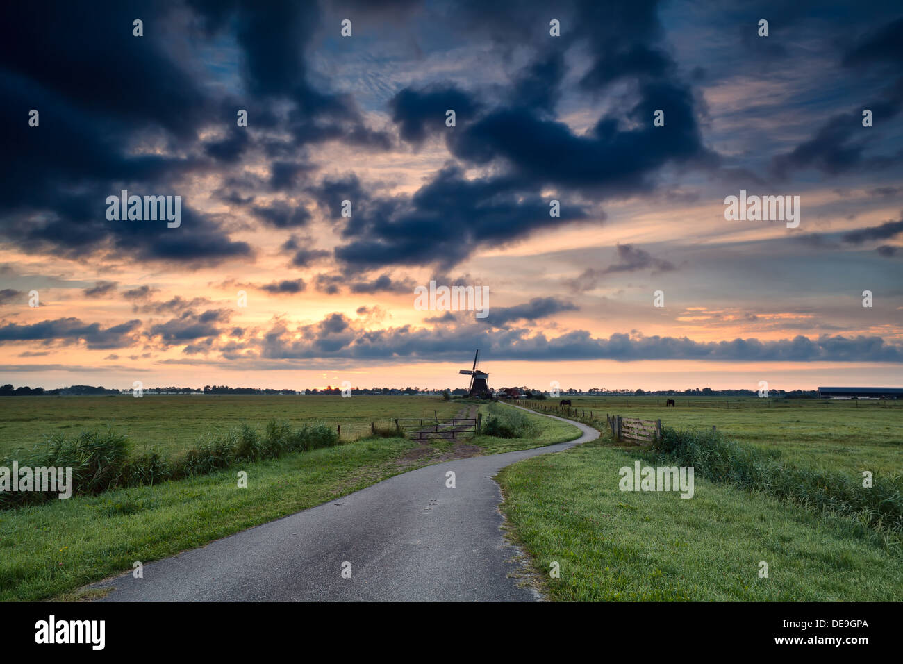 bike path to windmill at summer sunrise, Holland Stock Photo Alamy