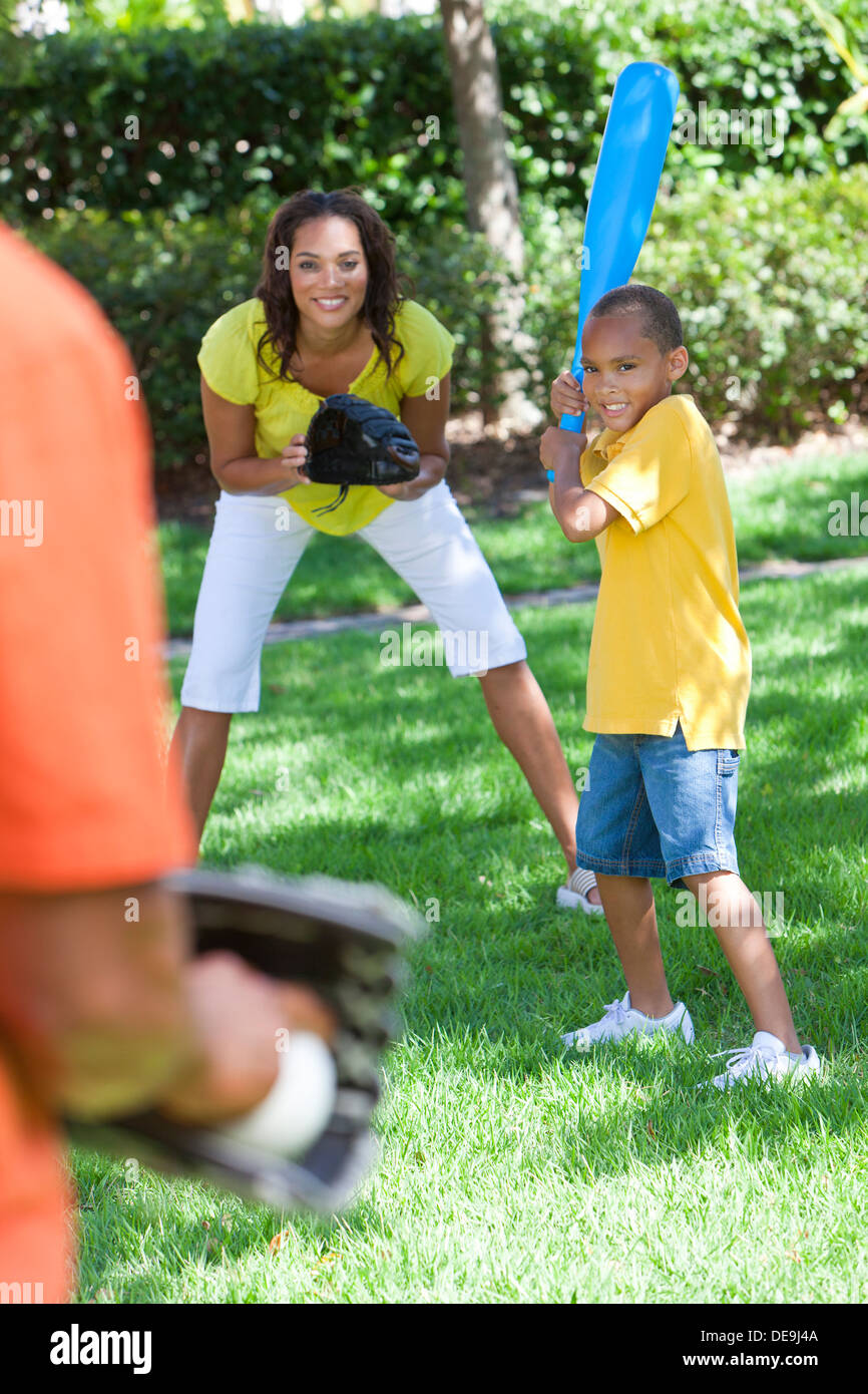 African American family, man, woman, boy child, mother, father, son playing baseball together outside Stock Photo