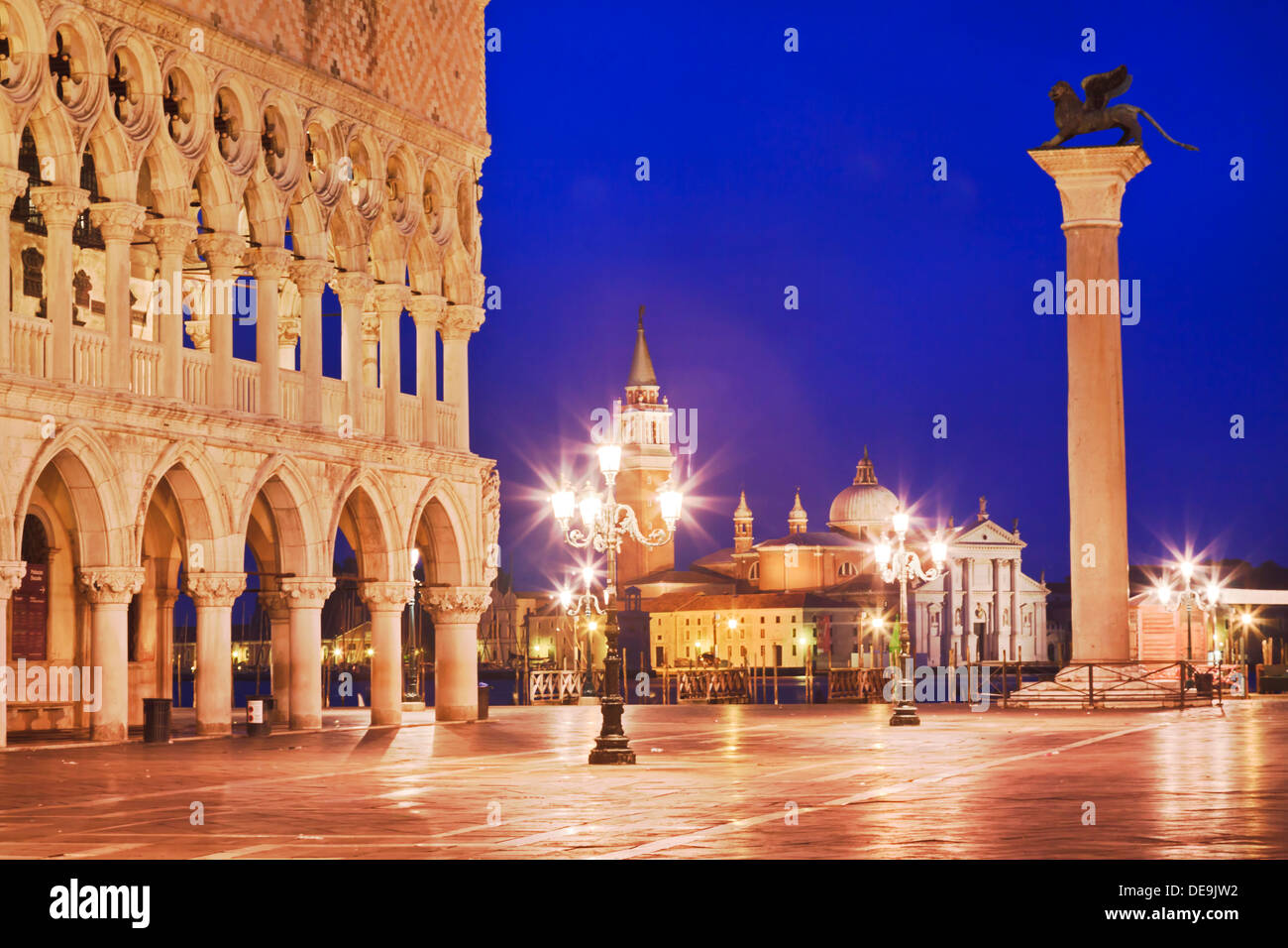 Italy Venice island grand canal and st marco piazza with palazzo Ducale palace and venetian column at sunrise with illiminated s Stock Photo