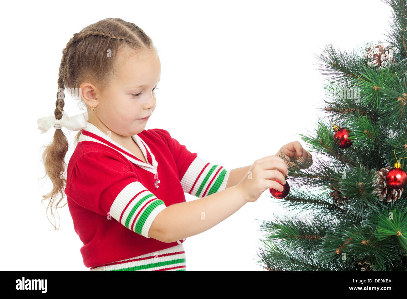 pretty preschool girl decorating Christmas tree isolated on white Stock Photo