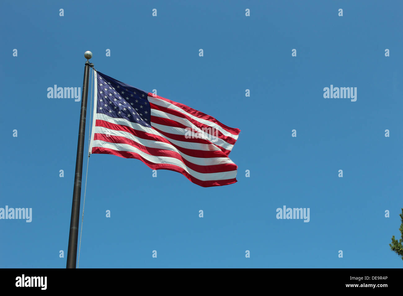 american flag waving against a bright blue sky Stock Photo - Alamy