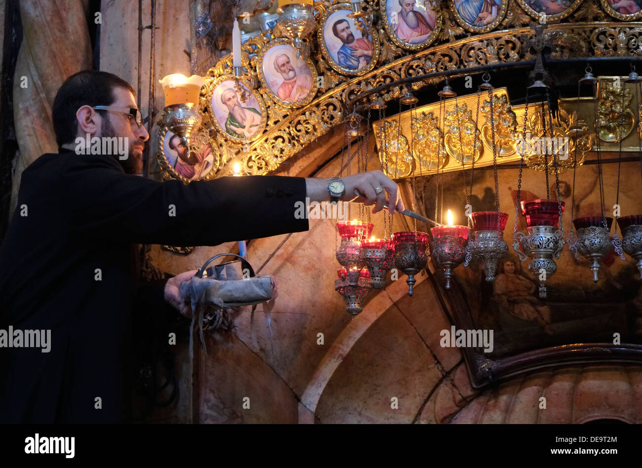 A Greek Orthodox priest lighting candles over the entrance to the Stock