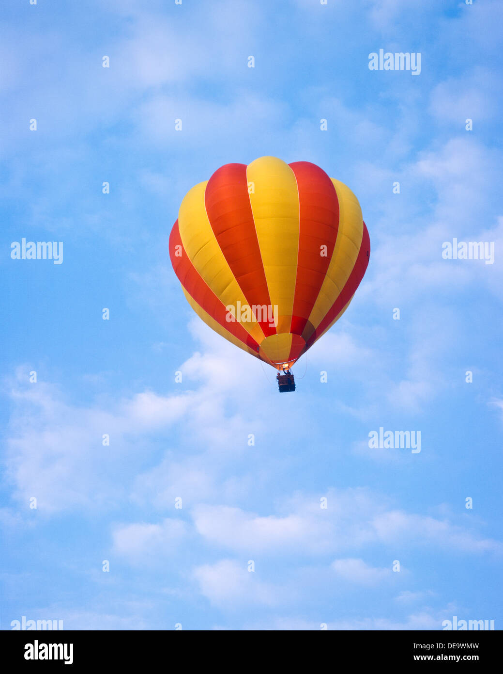 Red and yellow hot air balloon in a blue sky Stock Photo - Alamy