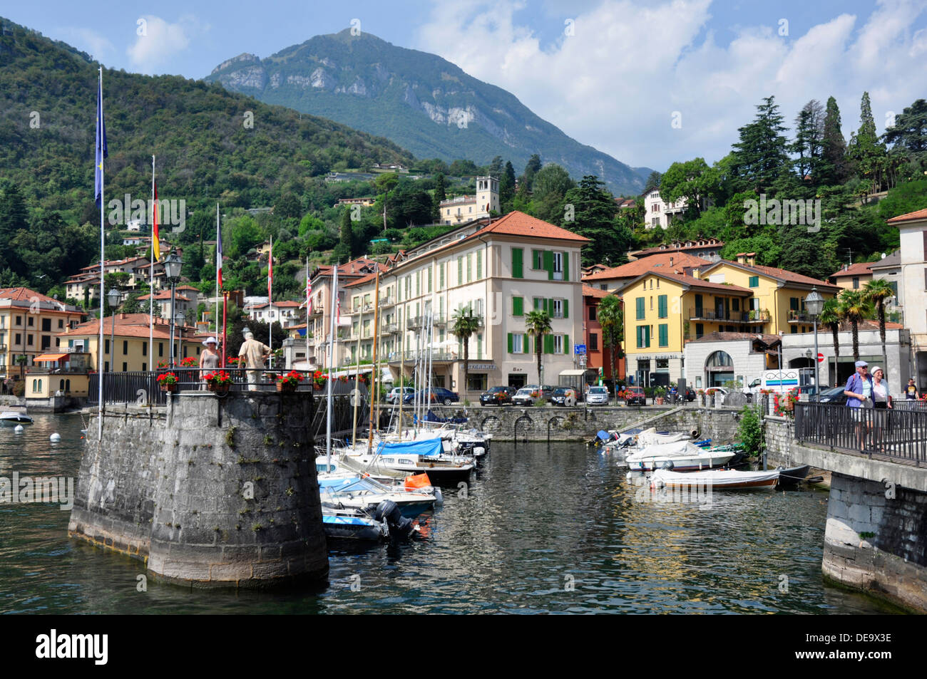 Italy  - Lake Como - Menaggio - the harbour - moored yachts - reflections - backdrop of the town and distant mountains Stock Photo