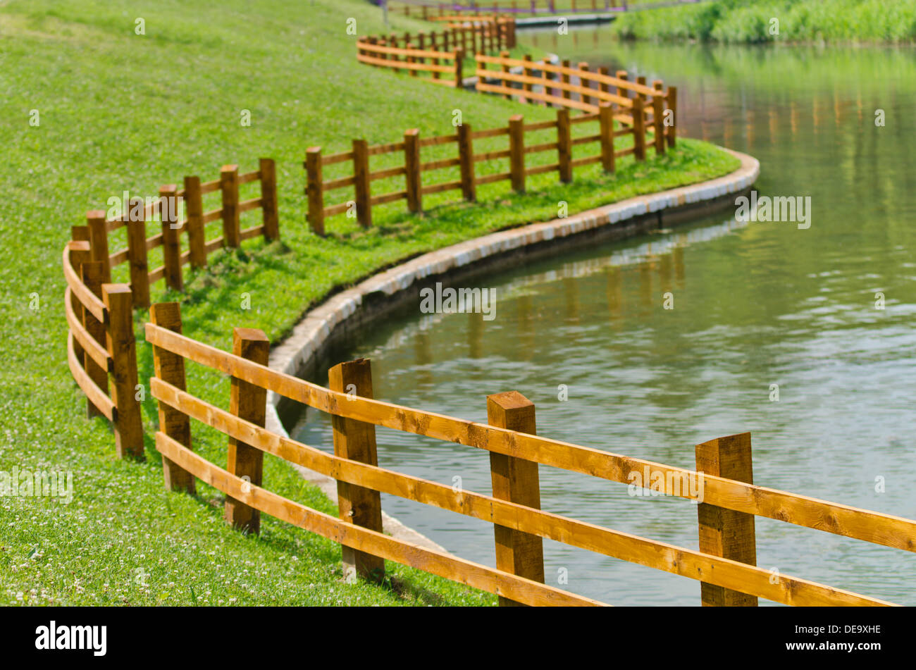 Curved shape fence around the pond Stock Photo Alamy