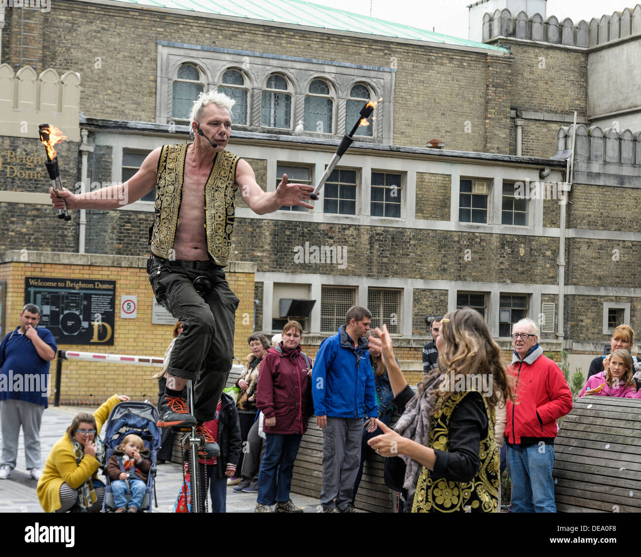 Brighton, UK, 14/09/2013 : A street performer on a high unicycle catches flaming juggling sticks. Picture by Julie Edwards Stock Photo