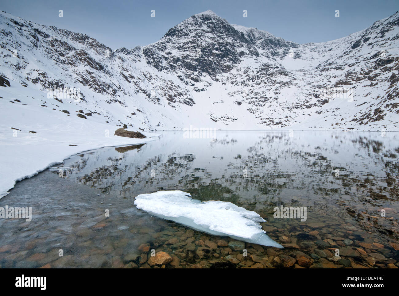 Ice Formations in Llyn Glaslyn and the Snow Capped Peak of Mount Snowdon, Snowdonia National Park, North Wales, UK Stock Photo