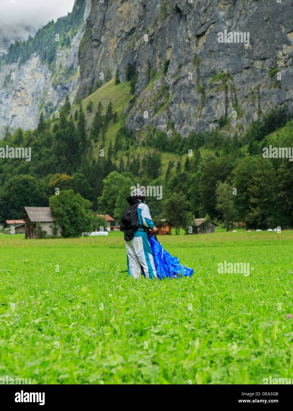 A photograph of a base jumper in front of a cliff face in Lauterbrunnen, Switzerland Stock Photo