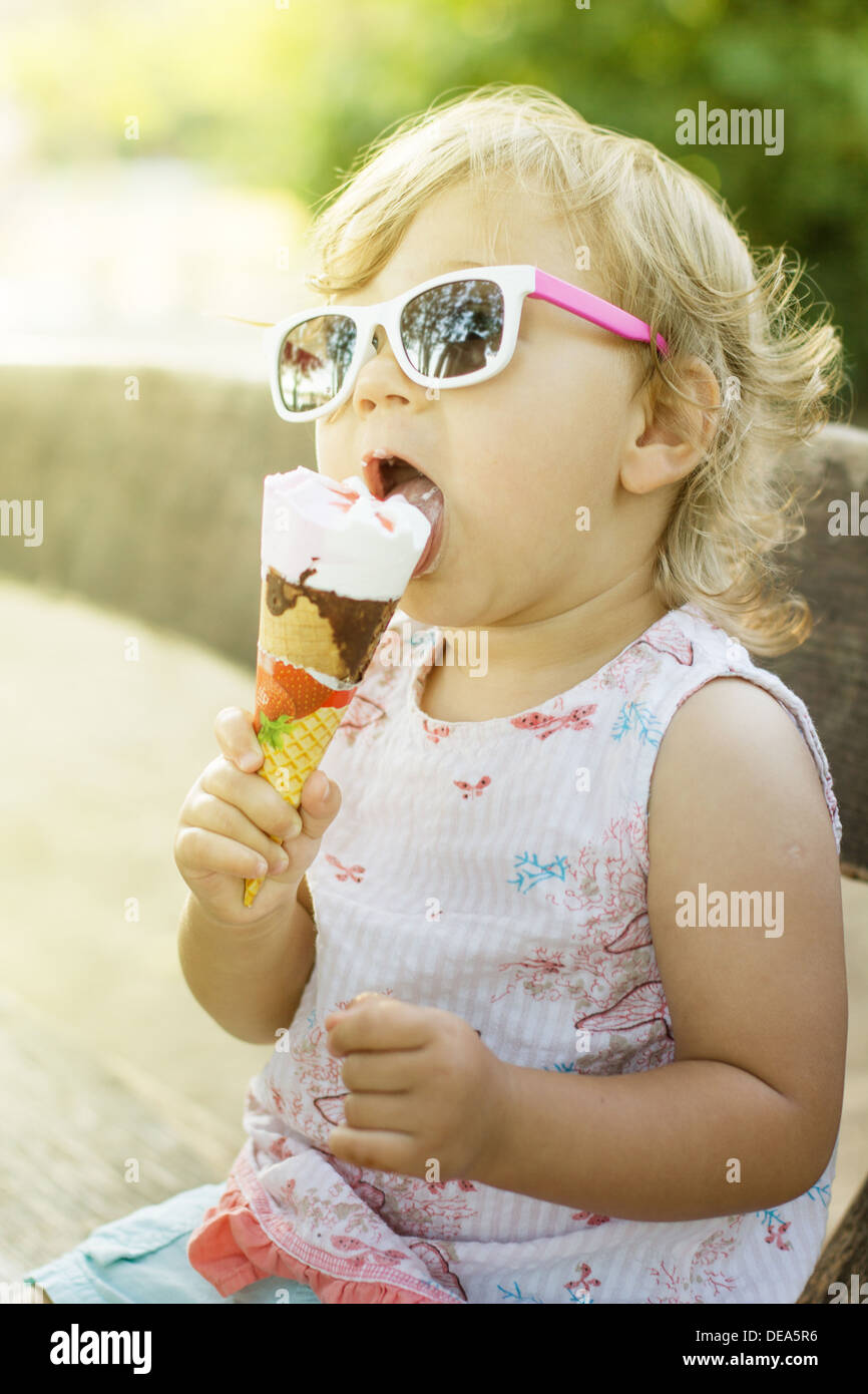 Cute baby girl eating ice cream outdoor Stock Photo - Alamy
