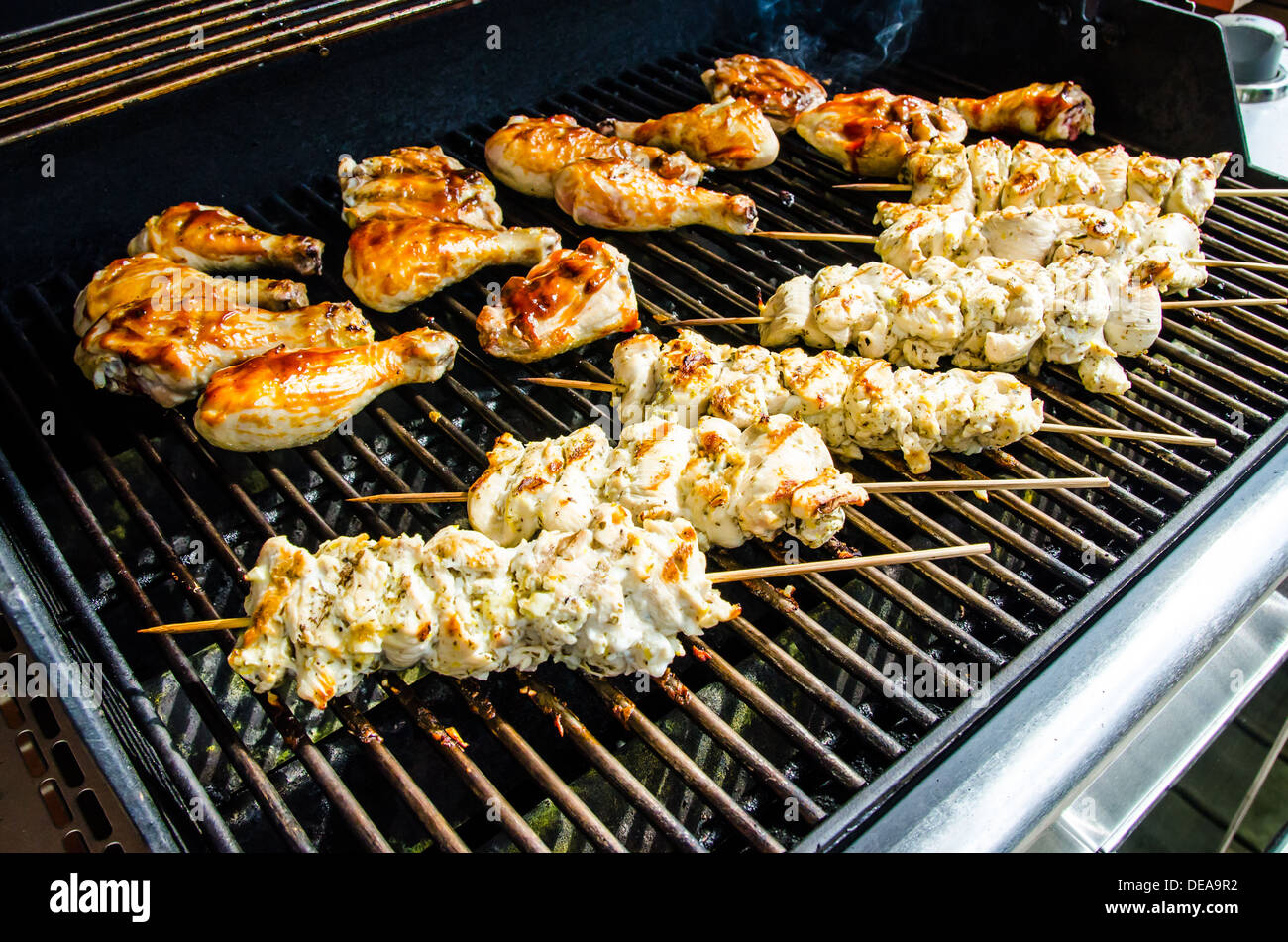 Backyard BBQ.  Chicken Souvlaki  and Chicken Legs on charcoal. Stock Photo