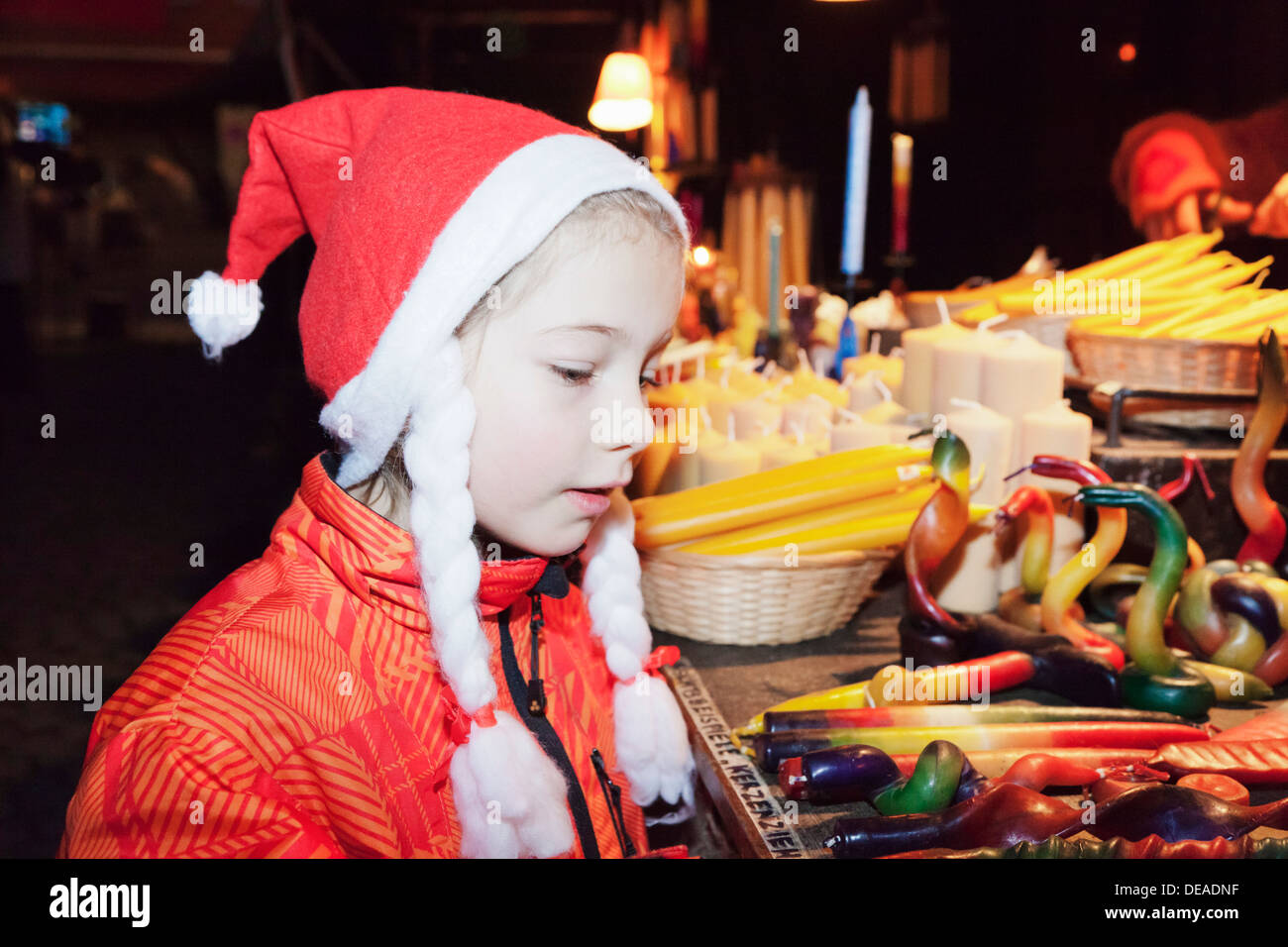 Eight year old girl at a candle stand at the Medieval Market at the Christmas fair, Esslingen, Baden Wurttemberg, Germany Stock Photo