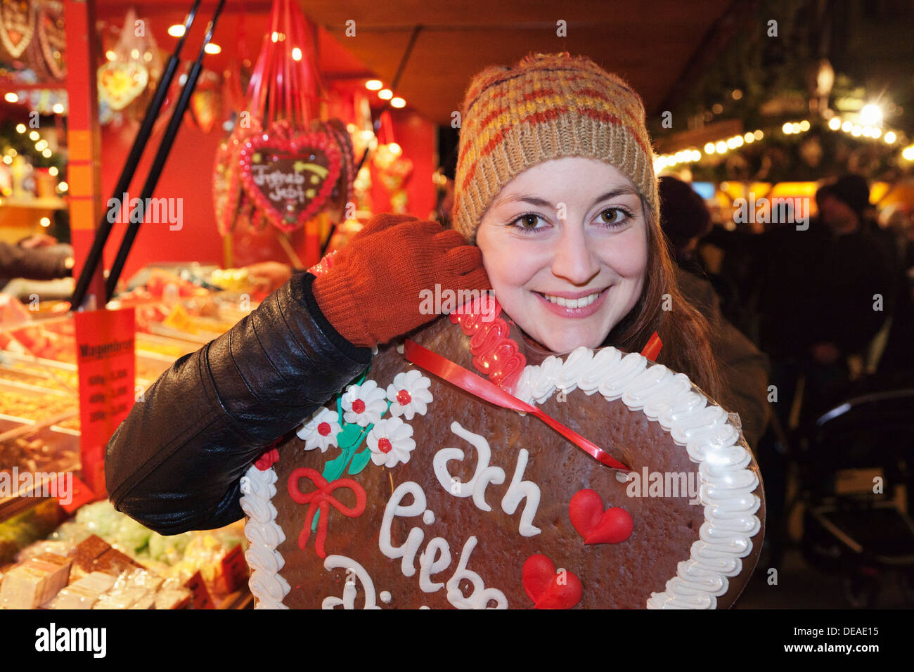 Young woman with a gingerbread heart at Christmas fair,  Esslingen, Baden Wurttemberg, Germany Stock Photo