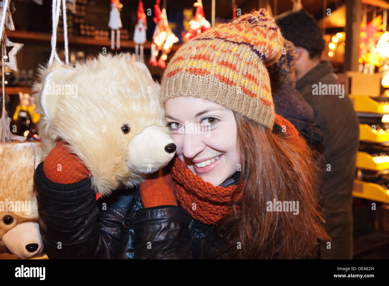 Young woman snuggle with a toy bear at the Christmas fair, Esslingen, Baden Wurttemberg, Germany Stock Photo