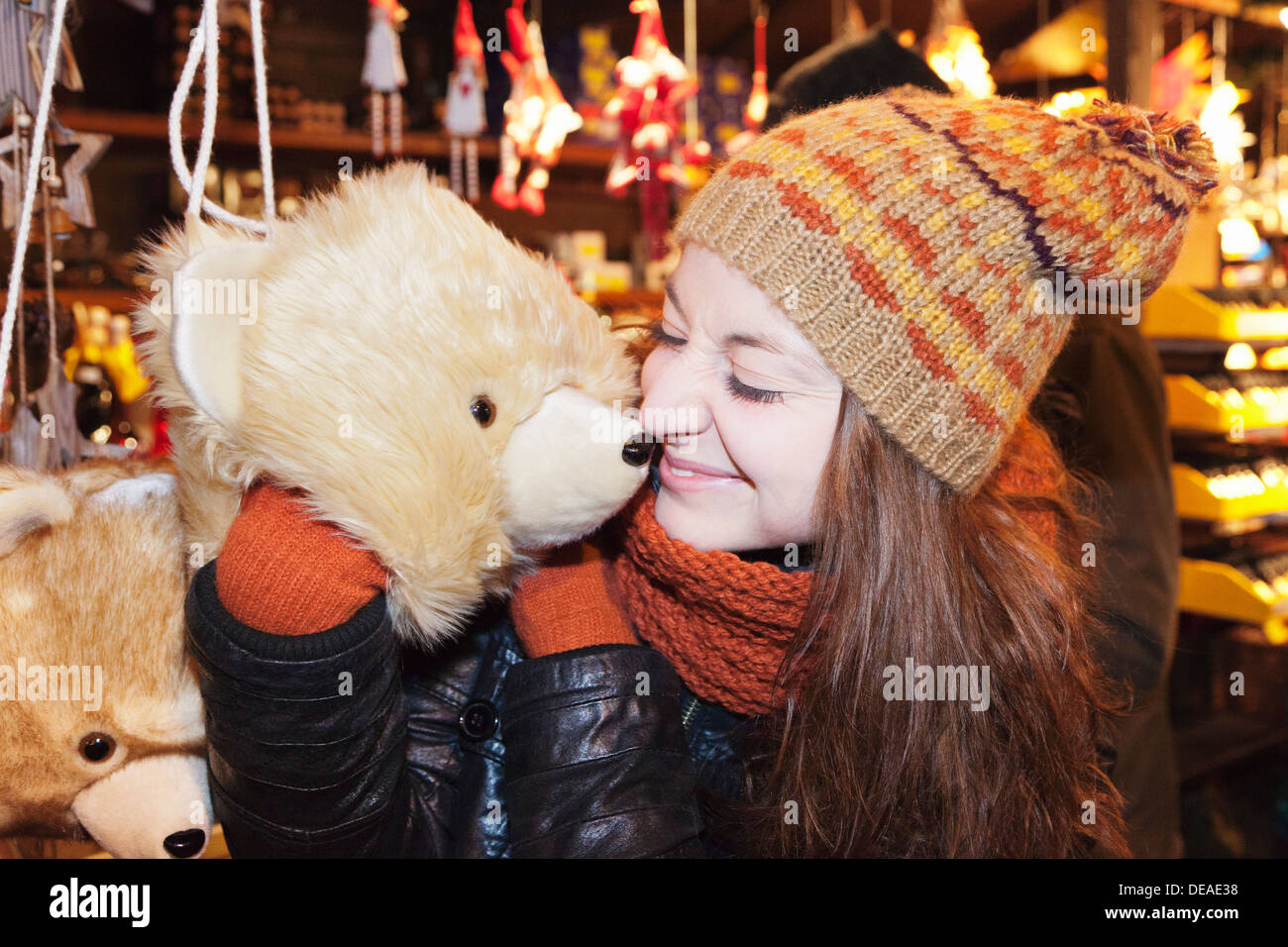 Young woman snuggle with a toy bear at the Christmas fair, Esslingen, Baden Wurttemberg, Germany Stock Photo