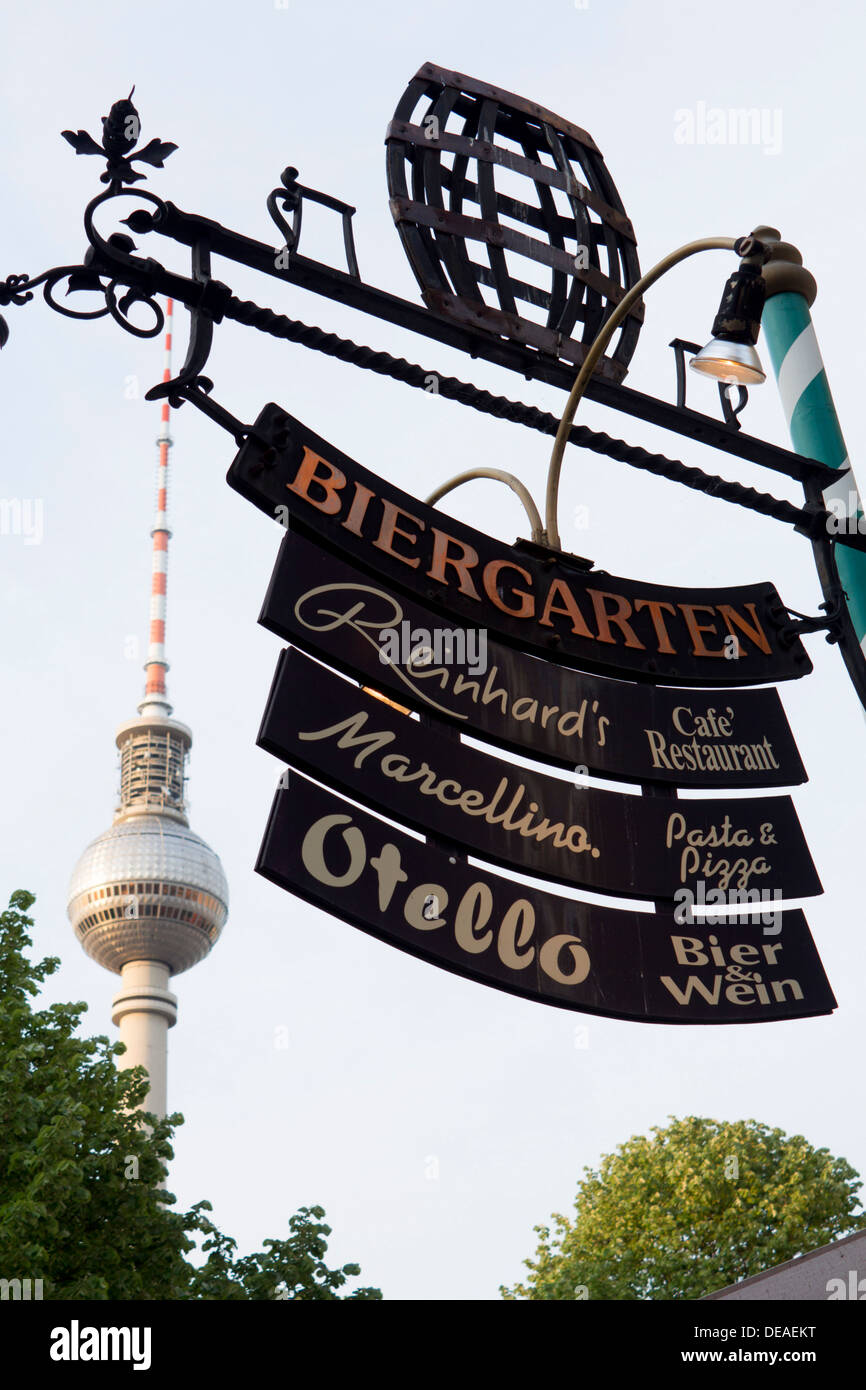 Beer Garden and restaurant signs in Nikolaiviertel with Fernsehturm TV Tower in background Mitte Berlin Germany Stock Photo