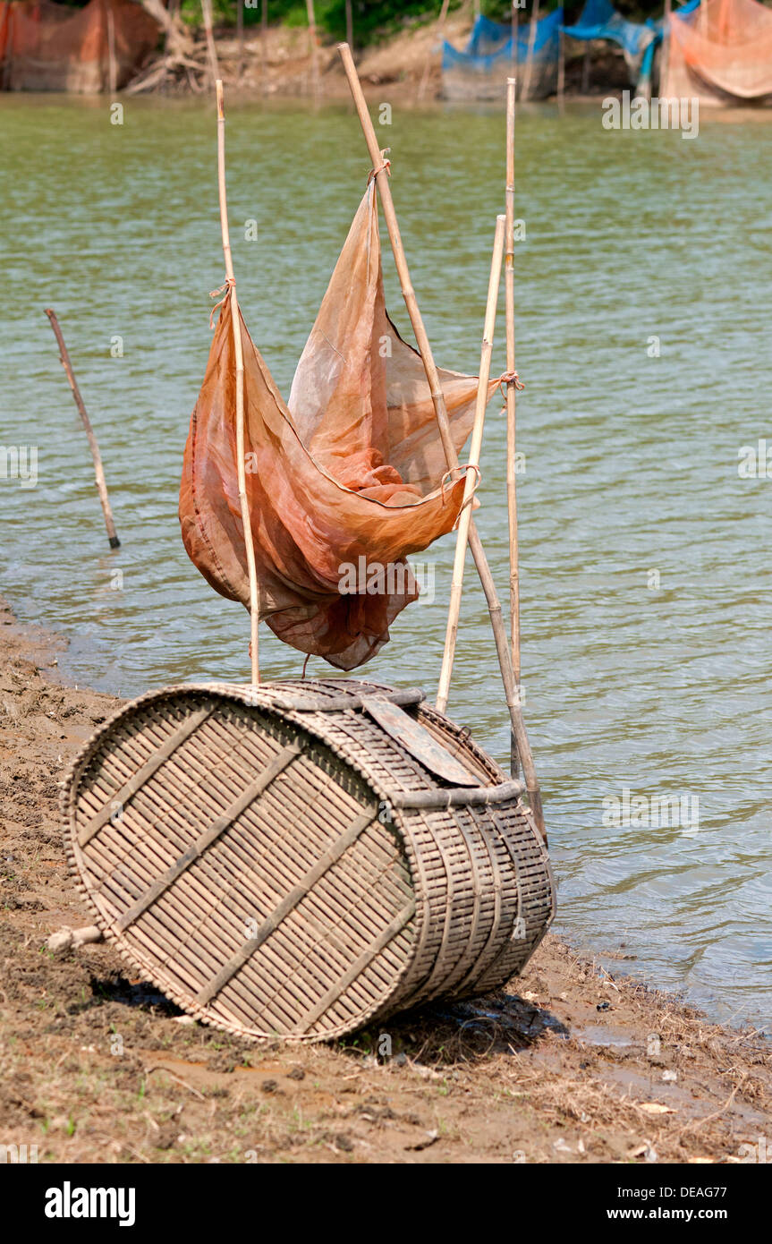Fish trap made of bamboo and a fishing net on the Sangkae river
